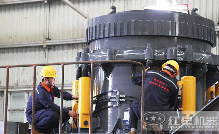 工作人員檢測圓錐破碎機，保障生產(chǎn)的設備都有高質量